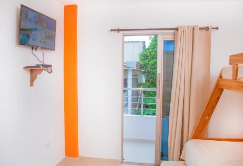 a bedroom with a sliding glass door to a balcony at Mama Lira in Coveñas