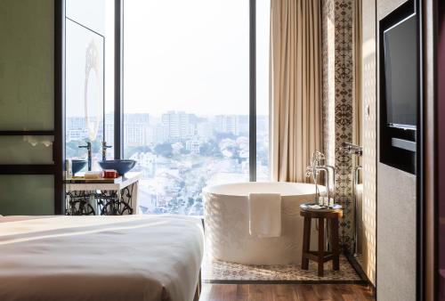 a bedroom with a tub and a large window at Hotel Indigo Singapore Katong, an IHG Hotel in Singapore