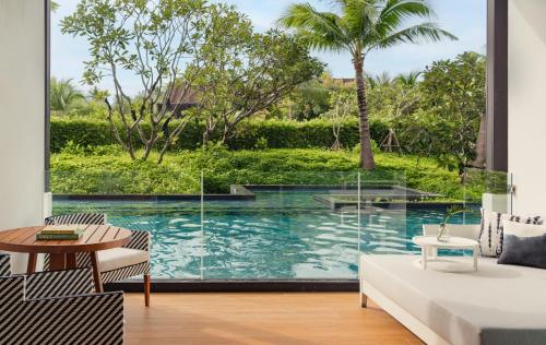 a living room with a view of a pool at Kimpton Kitalay Samui, an IHG Hotel in Choeng Mon Beach