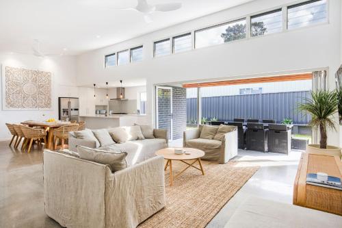 a living room with a couch and a table at Bathers Pet Friendly 4 Mins Walk to Beach in Culburra Beach