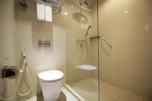a bathroom with a toilet and a glass shower at Hotel Santika Premiere Jogja in Yogyakarta