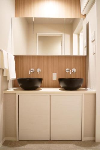 two sinks on a counter in a bathroom at Koti Sopo Universal Bay 4 by Liaison in Osaka