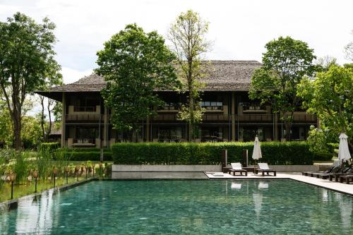 a swimming pool in front of a building at Kirimaya Golf Resort Spa - SHA Plus Certified in Mu Si