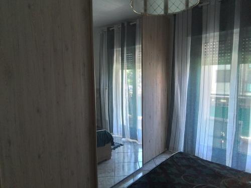a room with a hallway with windows and a bed at Casa di Max - private room in apartment with shared bathroom FREE PARKING in Bolzano