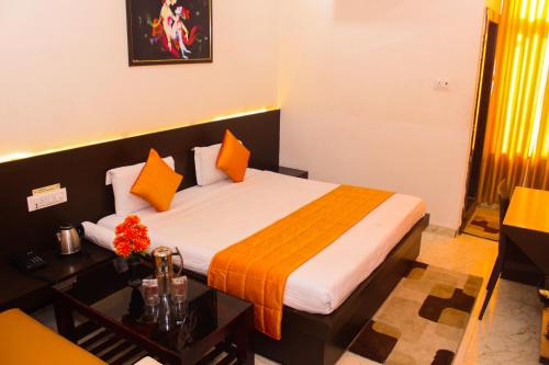 a hotel room with a bed and a table with flowers at The कस्तूरी in Maihar
