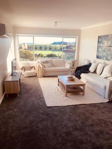 a living room with a couch and a table at Beautiful 4-bedroom original beach cottage in Port Kembla in Port Kembla