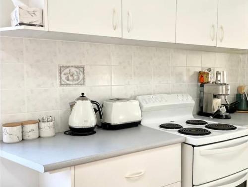 a kitchen with a white stove and a counter top at Beautiful 4-bedroom original beach cottage in Port Kembla in Port Kembla