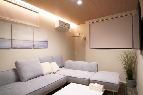 a living room with a couch and a screen at Koti Sopo Universal Bay 4 by Liaison in Osaka