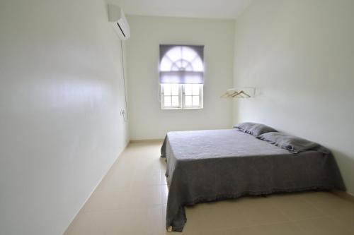 a white room with a bed and a window at D'Ja Smoke Homestay in Kampong Wakaf Tengah