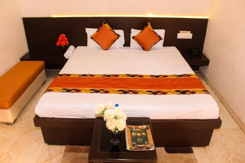 a bedroom with a bed with orange and yellow pillows at The कस्तूरी in Maihar
