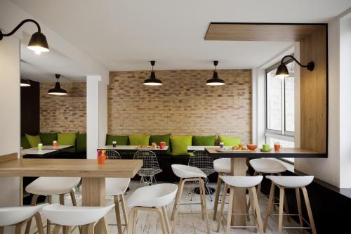 a restaurant with tables and chairs and a brick wall at ibis Styles Paris Buttes Chaumont in Paris