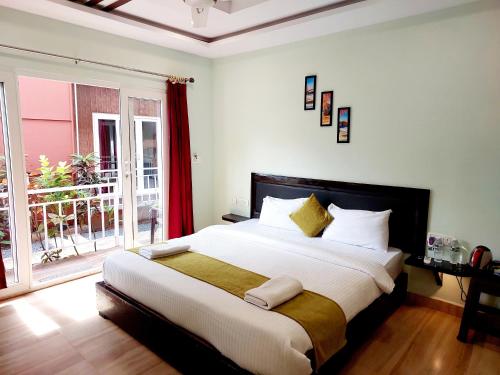 a bedroom with a large bed and a large window at Vedana Retreat Arambol in Arambol