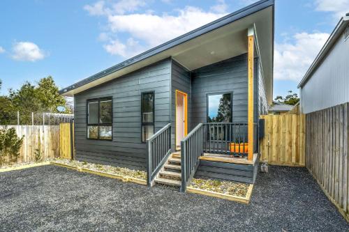 a small house with a gray siding at The House with the Orange Door, Inverloch in Inverloch