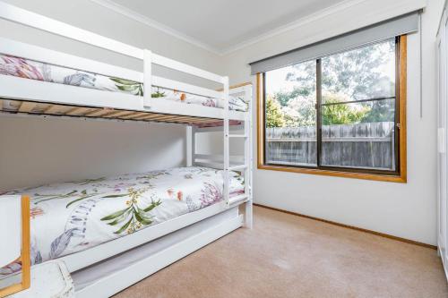 インヴァーロックにあるBreathe easy Inverloch linen and wifi includedのベッドルーム1室(二段ベッド、窓付)