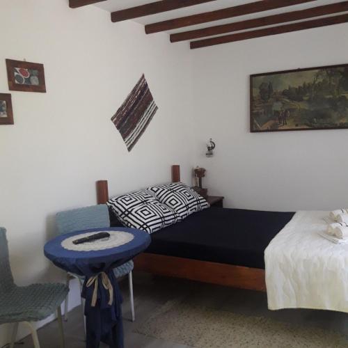 sypialnia z łóżkiem, stołem i krzesłem w obiekcie Sljivik w Niszu