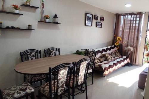 a dining room with a table and chairs and a couch at Casa Club Vacacional in Ica