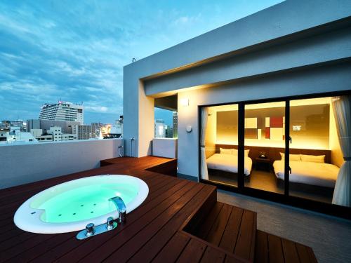 a bathroom with a bath tub on a balcony at Rakuten STAY Naha-Miebashi Suite Room in Naha