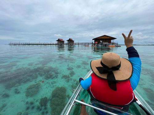 a person in a hat in a boat in the water at Pavalintang Resort in Semporna