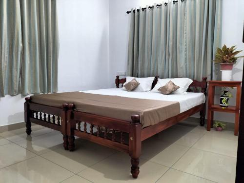1 dormitorio con cama de madera con sábanas blancas en joseys homestay, en Kochi