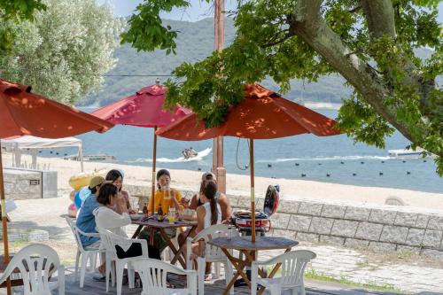 a group of people sitting at tables under umbrellas at a beach at SETOUCHI SUP RESORT - Ao - in Shodoshima