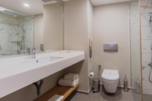 ヒサルヌにあるFortezza Beach Resortの洗面台とトイレのある白いバスルーム