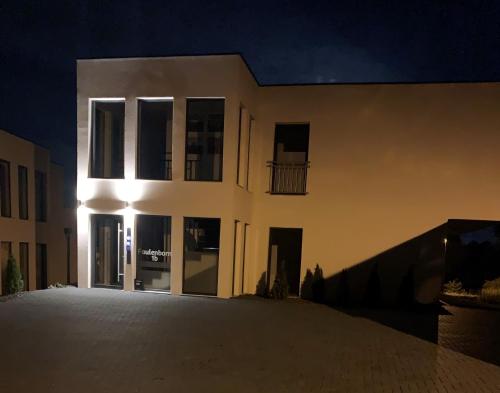 a large white building at night with the lights on at eifel24, neu, modern mit Dachterrasse in Schwirzheim