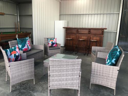 a group of chairs and a table and a piano at CandE on Samphire in Kingscote
