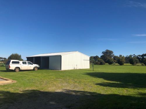 a white truck parked in a field next to a building at CandE on Samphire in Kingscote