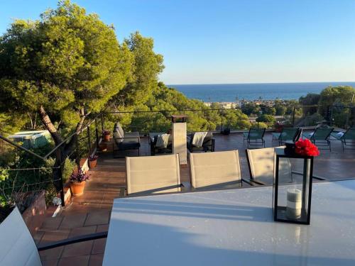 un balcón con sillas y una mesa con un jarrón de flores en Villa Bella, en Castelldefels