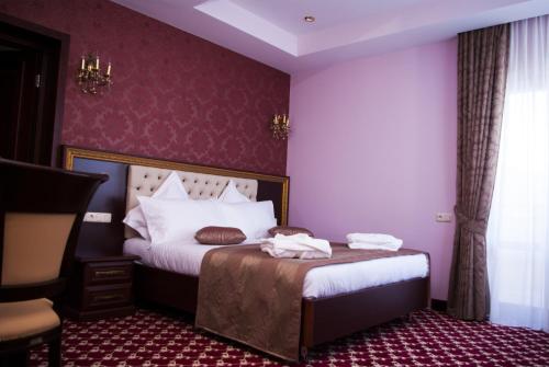 a bedroom with a bed with purple walls at Multi Rest House in Tsaghkadzor