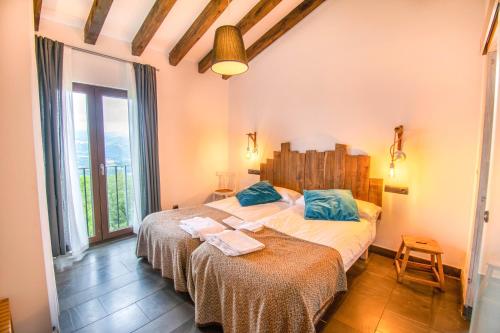 1 Schlafzimmer mit 2 Betten und einem großen Fenster in der Unterkunft Behin Batean, espectacular casa rural en pleno corazón del valle Baztán in Ziga