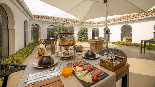 einen Tisch mit Essen drauf mit einem Regenschirm in der Unterkunft Hotel Boutique Canelobre in Busot