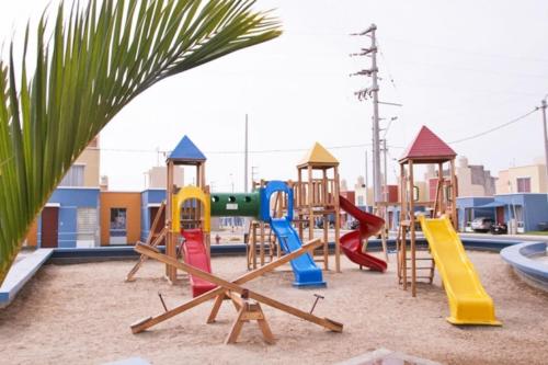 un parque infantil con tobogán y columpios en Casa Club Vacacional en Ica