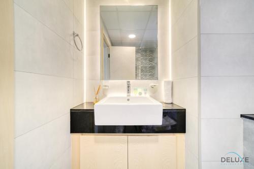 y baño con lavabo blanco y espejo. en Homely 1BR at Binghatti Avenue Al Jaddaf by Deluxe Holiday Homes, en Dubái