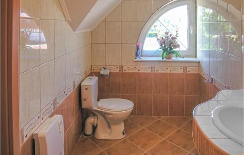 a bathroom with a toilet and a sink and a window at 4 Bedroom Lovely Home In Rowy in Rowy