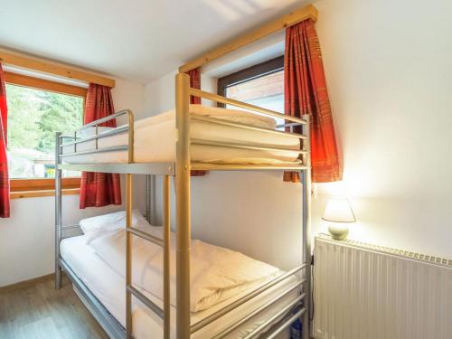 a bunk bed in a small room with a window at Private Holiday Home in Mariapfarr with Lovely Garden in Mariapfarr