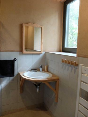 La salle de bains est pourvue d'un lavabo et d'un miroir. dans l'établissement Gite et cabane écologiques 1000 Pailles, à Labastide-de-Virac