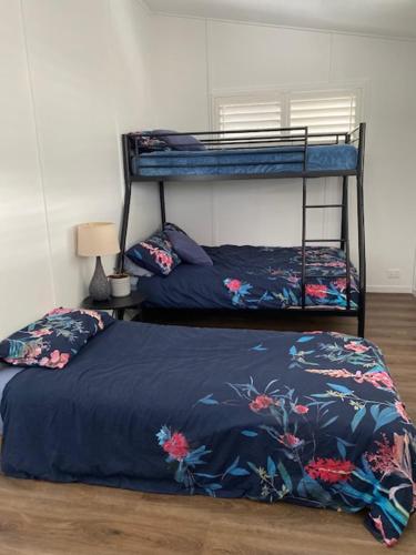 a bedroom with a bunk bed with a blue blanket at Palm Beach the best trending place on the Coast in Gold Coast