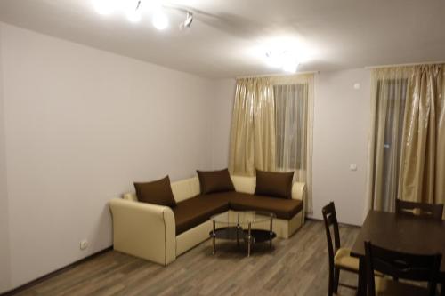 a living room with a couch and a table at ENIS Hotel с минерален басейн in Sapareva Banya