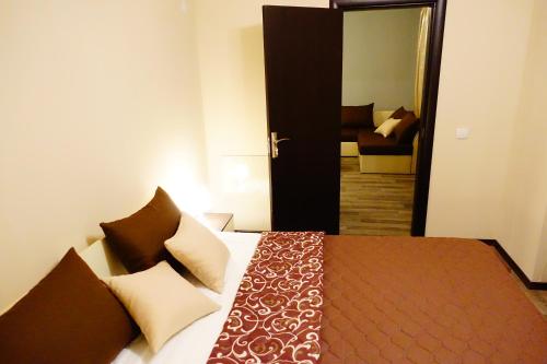 een slaapkamer met een bed en een deur naar een kamer bij ENIS Hotel с минерален басейн in Sapareva Banya