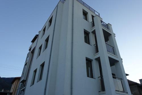 a white building with windows on the side of it at ENIS Hotel с минерален басейн in Sapareva Banya
