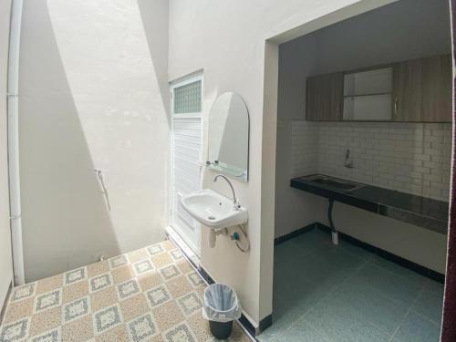 ein Badezimmer mit Waschbecken und Spiegel in der Unterkunft RedDoorz Plus at Orange Diponogoro Palangkaraya in Palangkaraya