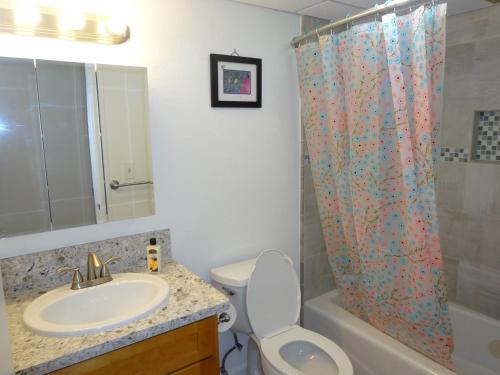 a bathroom with a sink and a shower curtain at Waikiki 2BR King Beds Short Walk to Convention and Beaches in Honolulu
