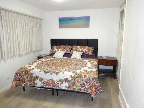1 dormitorio con 1 cama y escritorio con colcha en Waikiki 2BR King Beds Short Walk to Convention and Beaches, en Honolulu