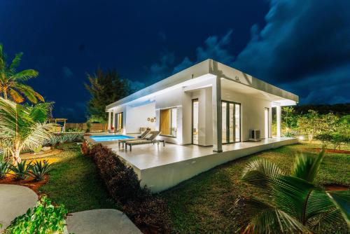 a white house with a patio and a swimming pool at Safira Blu Luxury Resort & Villas in Nungwi