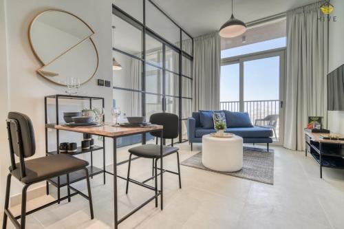 a living room with a table and chairs and a mirror at Lovely 1 Bedroom Apartment in Collective 2.0 in Dubai