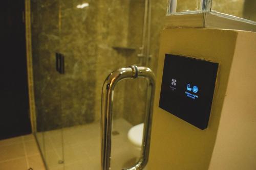 y baño con ducha y lavamanos. en Cebu Dulcinea Hotel and Suites-MACTAN AIRPORT HOTEL en Isla de Mactán