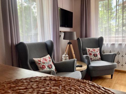 ザコパネにあるMarina Zakopaneのベッドルーム1室(椅子2脚、ベッド1台、窓付)