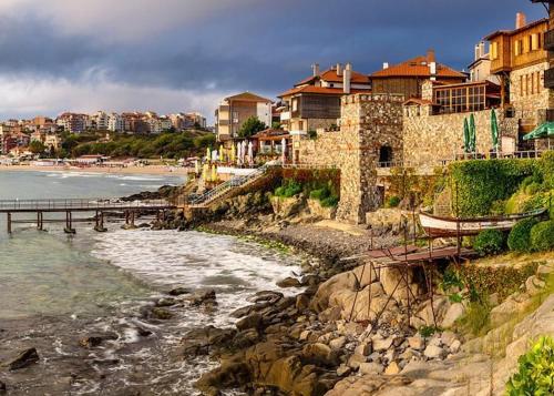 a view of a beach with a pier and buildings at Elite Apartments is located in the old town of Pomorie in Pomorie