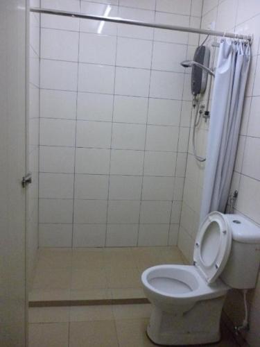 a bathroom with a toilet with a shower curtain at Abby by the river in Ipoh